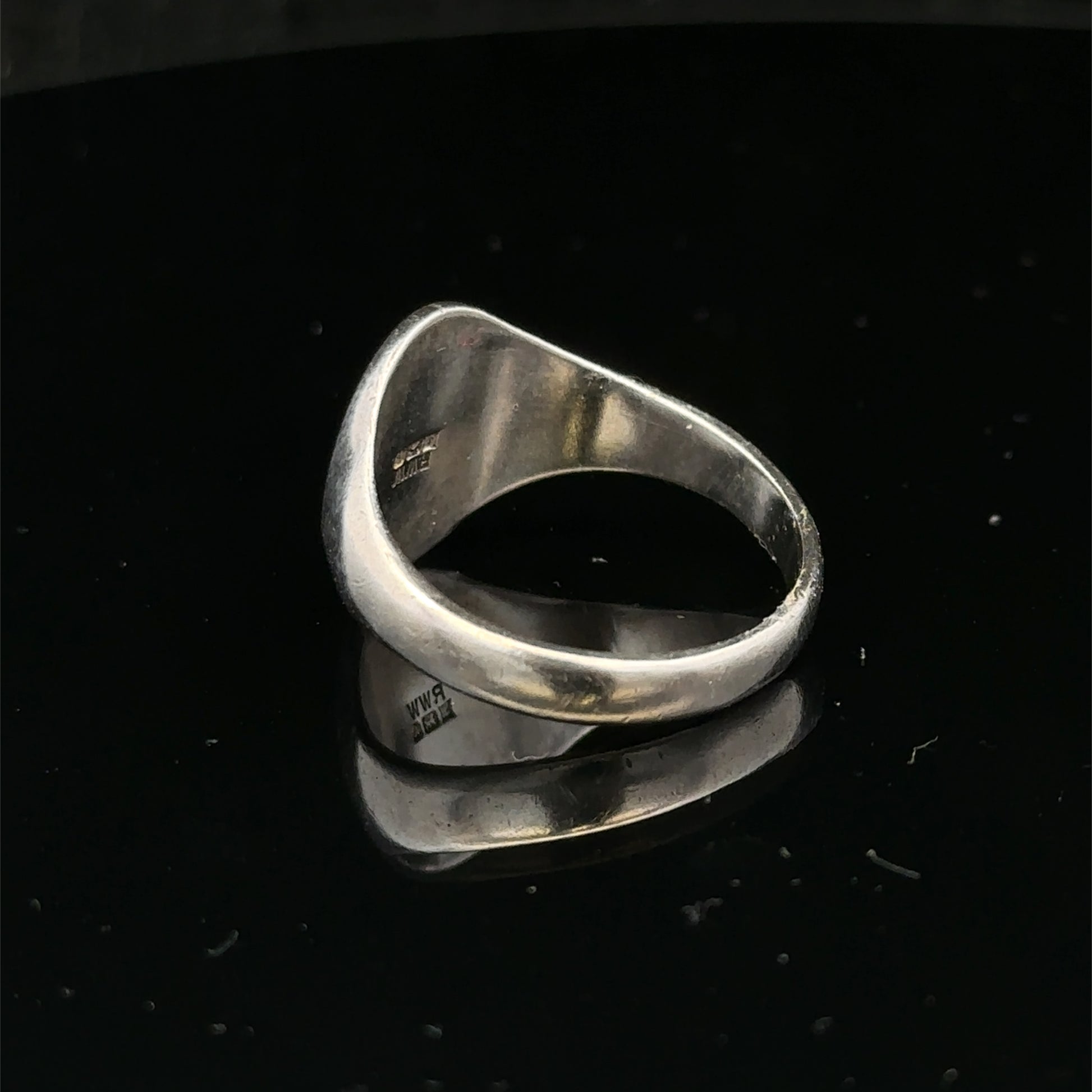 Silver signet ring by Reeves and Sons, size S1/2, featuring a smooth polished surface and classic design.