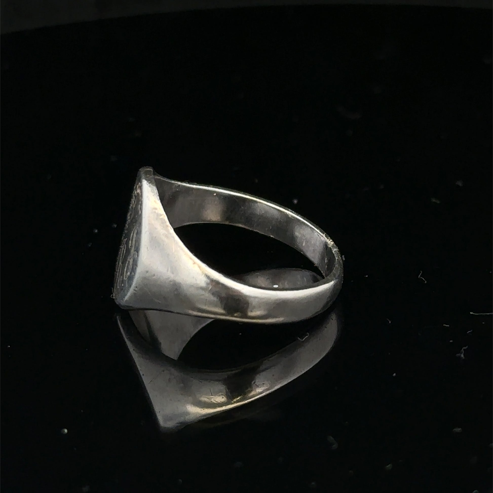 Silver signet ring by Reeves and Sons in size S1/2, featuring a smooth, polished surface and classic design.
