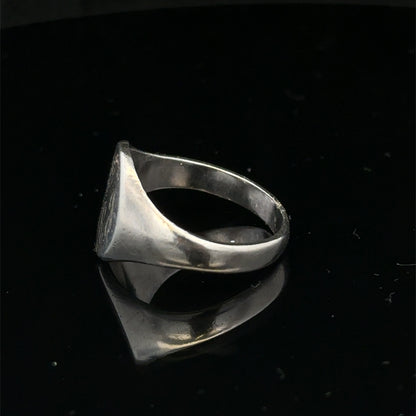 Silver signet ring by Reeves and Sons in size S1/2, featuring a smooth, polished surface and classic design.