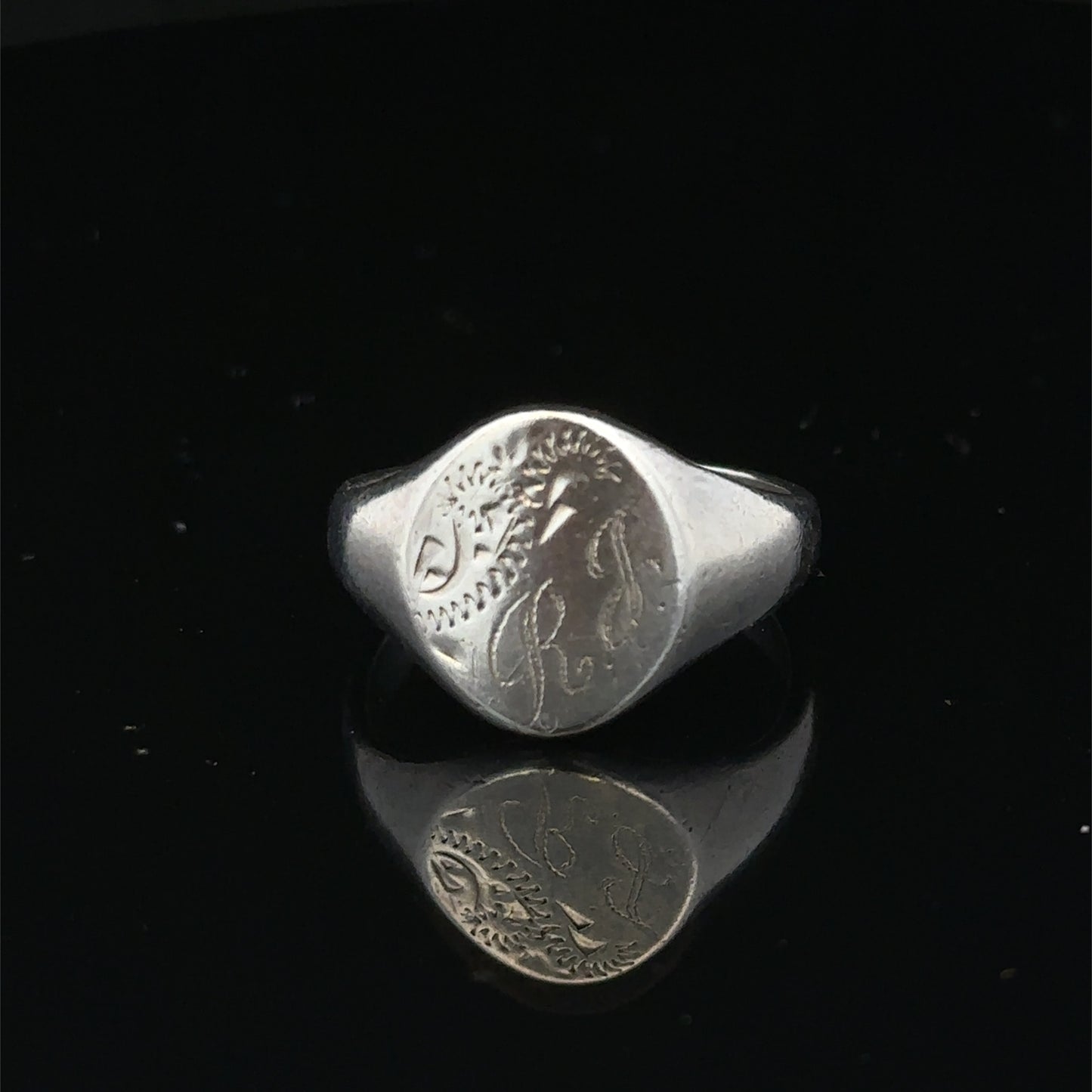 Silver signet ring from Reeves and Sons in size S1/2, featuring a smooth, polished surface and classic design.