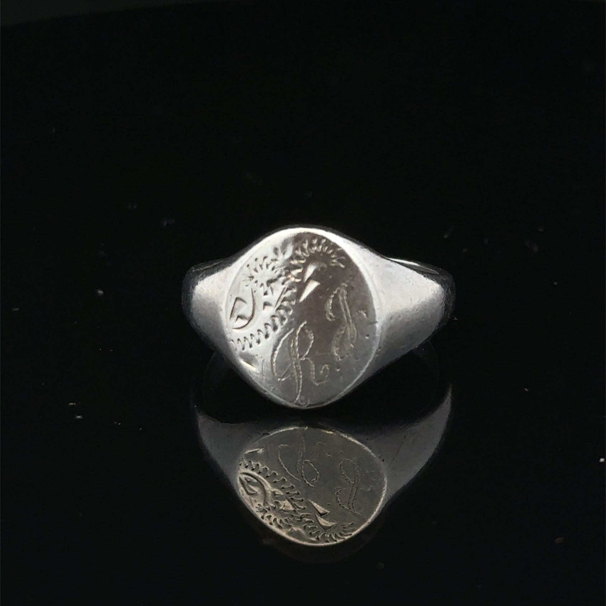 Silver signet ring from Reeves and Sons in size S1/2, featuring a smooth, polished surface and classic design.