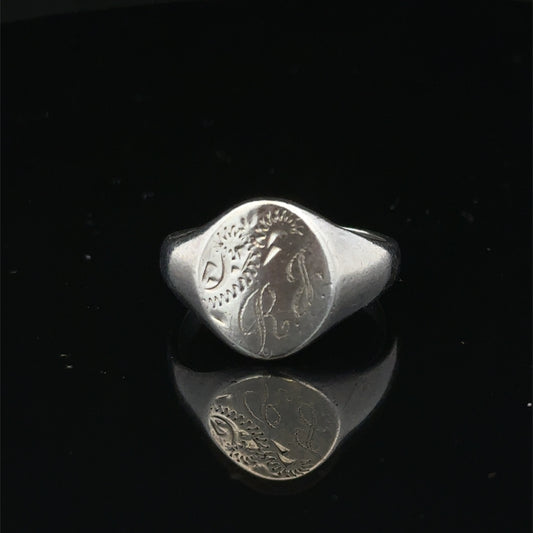 Silver signet ring from Reeves and Sons in size S1/2, featuring a smooth, polished surface and classic design.