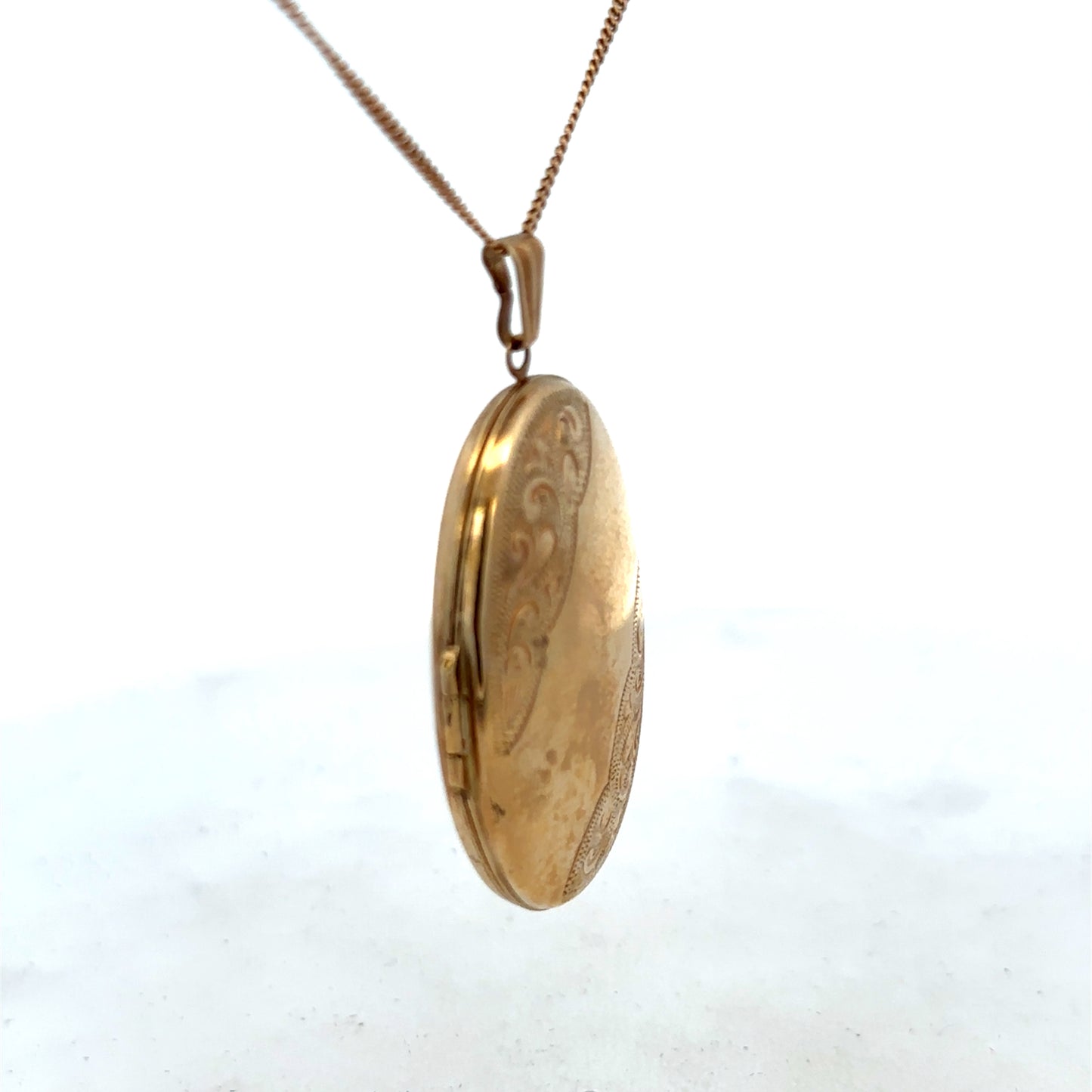 9ct yellow gold locket pendant by Reeves and Sons, 6.6g, showcasing a smooth, polished surface with intricate detailing.