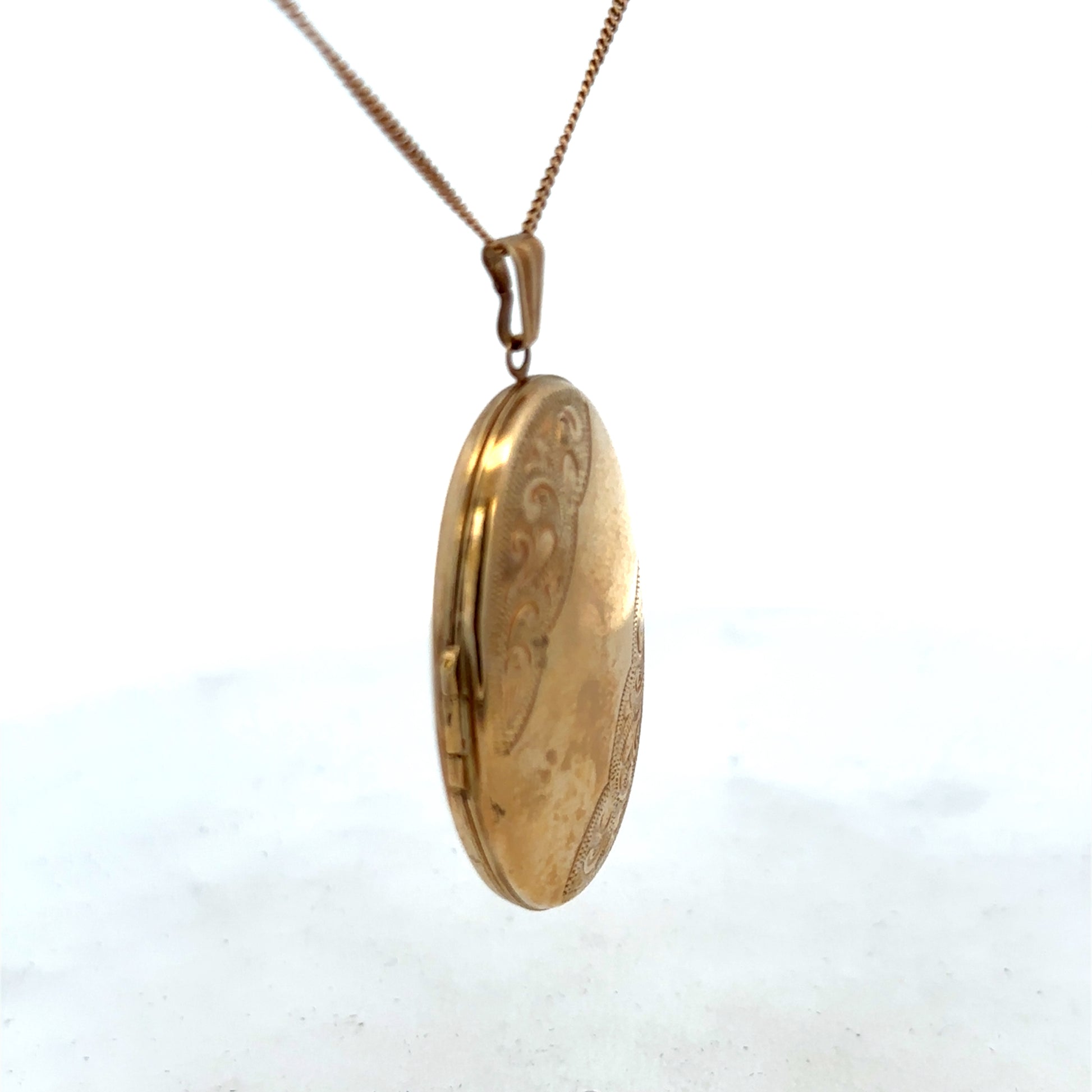 9ct yellow gold locket pendant by Reeves and Sons, 6.6g, showcasing a smooth, polished surface with intricate detailing.