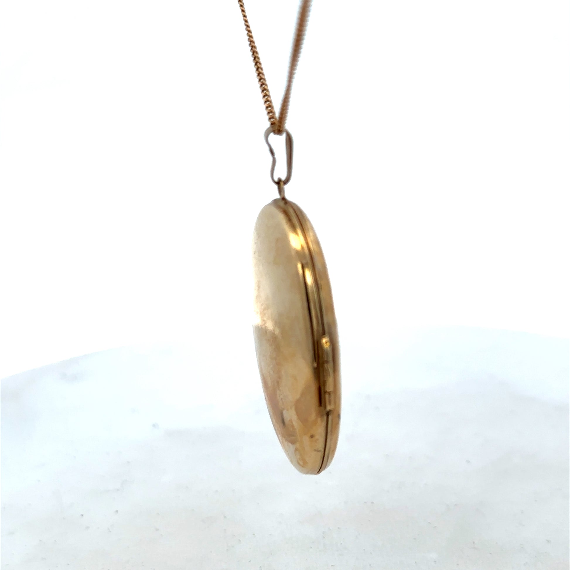 9ct yellow gold locket pendant with intricate design, weighing 6.6g, from Reeves and Sons, showcased against a neutral background.