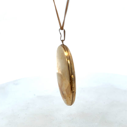 9ct yellow gold locket pendant with intricate design, weighing 6.6g, from Reeves and Sons, showcased against a neutral background.