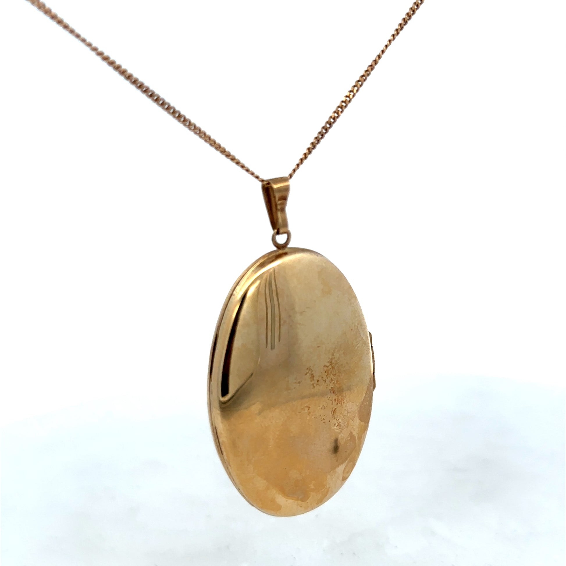 9ct yellow gold locket pendant with intricate design, weighing 6.6g, from Reeves and Sons, shown in close-up detail.