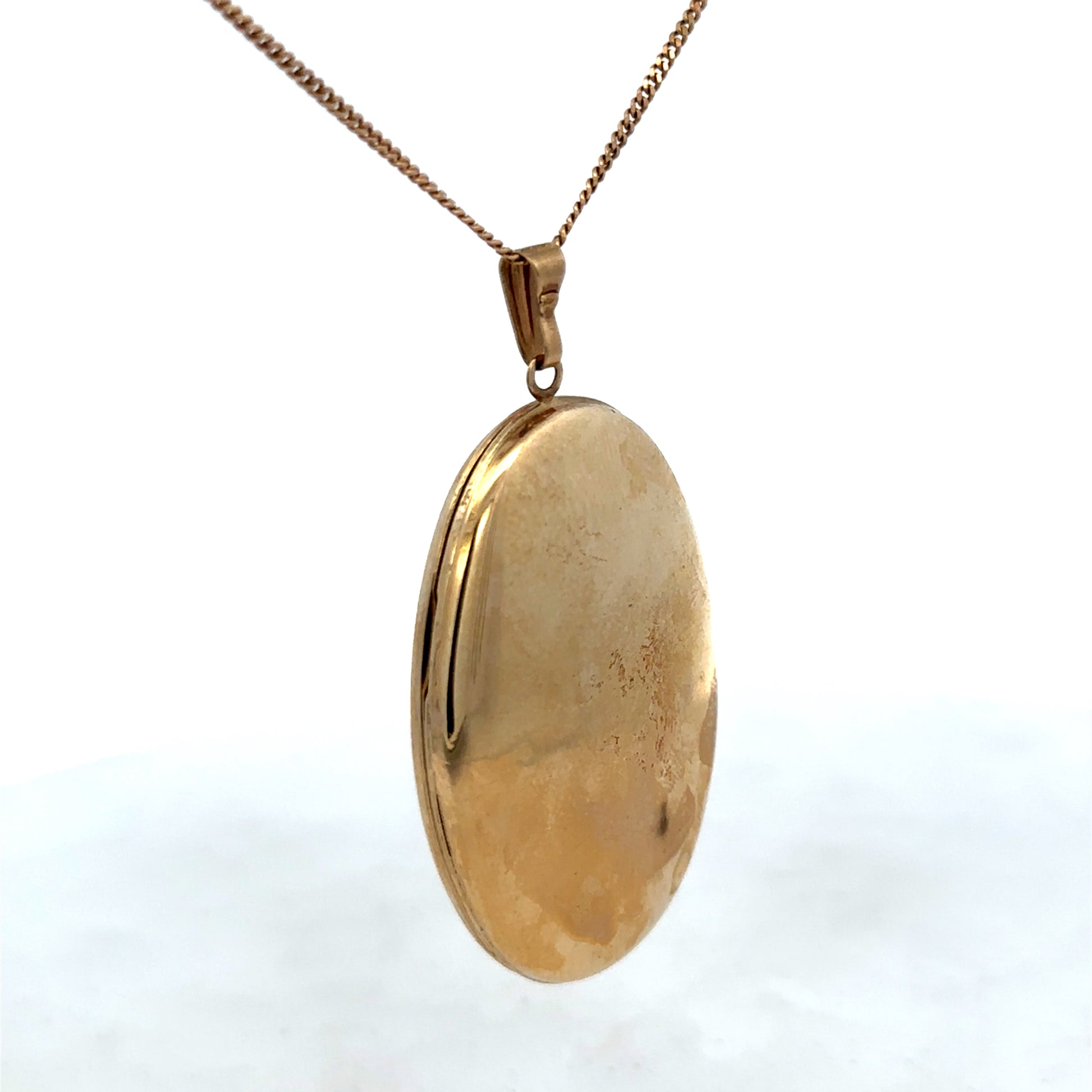 9ct yellow gold locket pendant by Reeves and Sons with intricate design, weight 6.6g, on a plain background.
