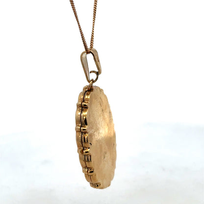 9ct yellow gold locket pendant by Reeves and Sons, showcasing a detailed design, weighs 8.1g, and features a classic pendant style.