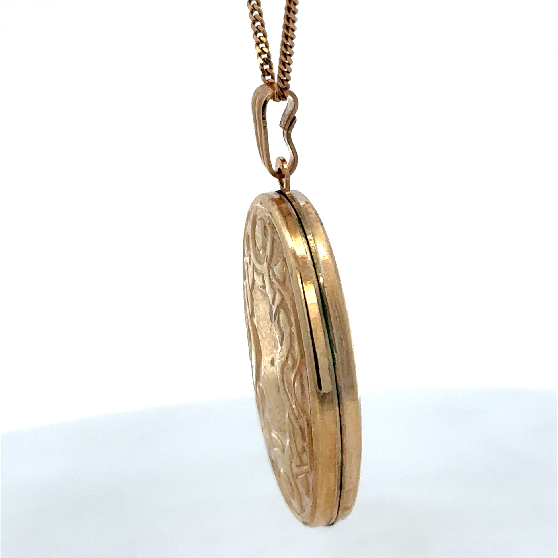 9ct yellow gold locket pendant from Reeves and Sons, weighing 3.4g, with detailed engraved design visible in the image.