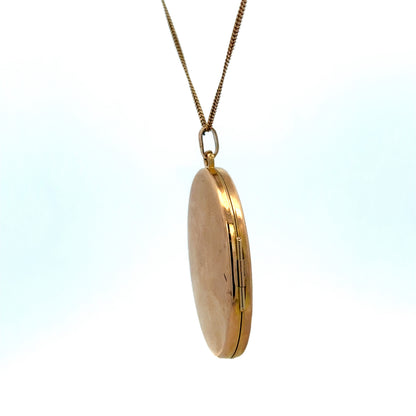 Reeves and Sons 9ct yellow gold locket pendant with intricate design, weighing 6.7g, displayed against a neutral background.