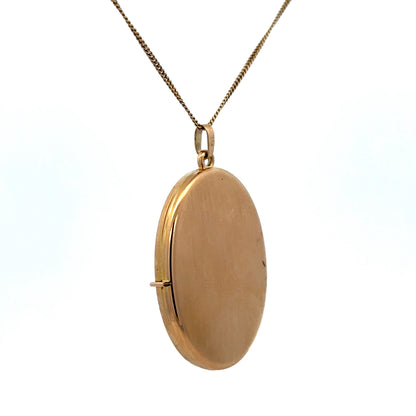 9ct yellow gold locket pendant with floral engraving, Reeves and Sons jewelry, showcasing intricate design and polished finish.