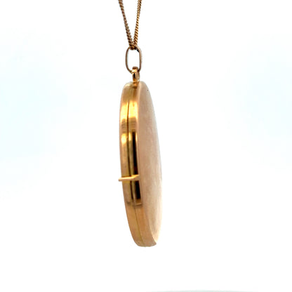 9ct yellow gold pendant locket by Reeves and Sons, featuring a smooth, polished surface and delicate chain attachment.