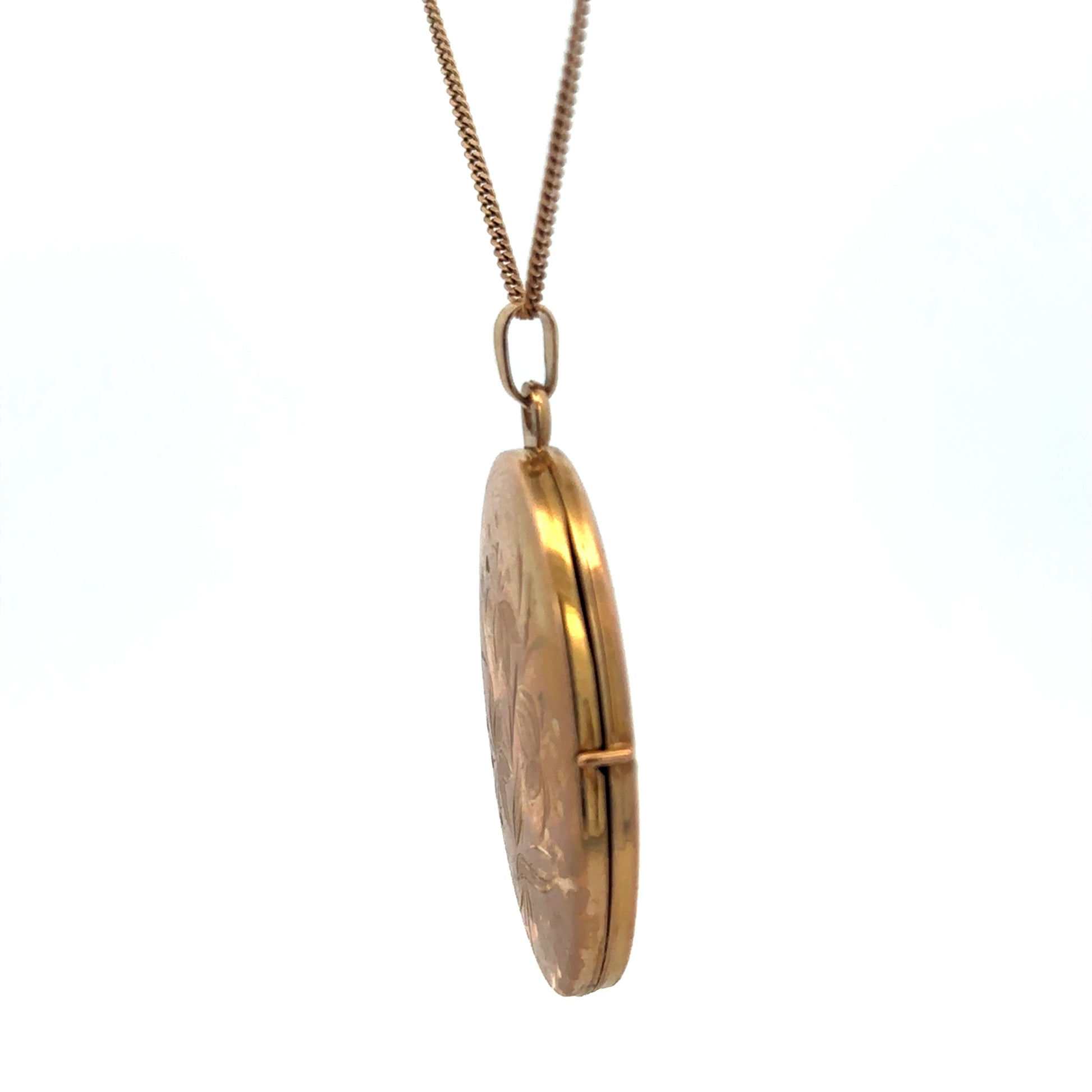 9ct yellow gold locket pendant with intricate design, weighing 4.7g, from Reeves and Sons, shown close-up.