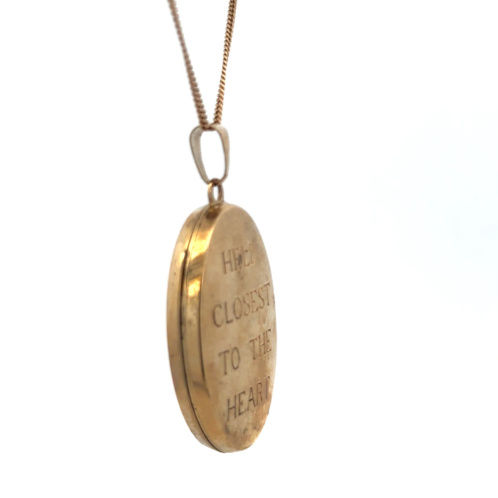 9ct yellow gold locket pendant by Reeves and Sons, detailed close-up showing intricate design and polished finish.