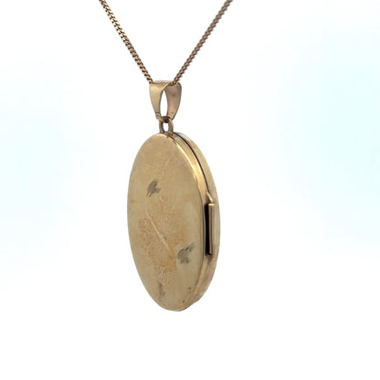 9ct yellow gold locket pendant with intricate engraved design, weighing 4.2g, by Reeves and Sons.