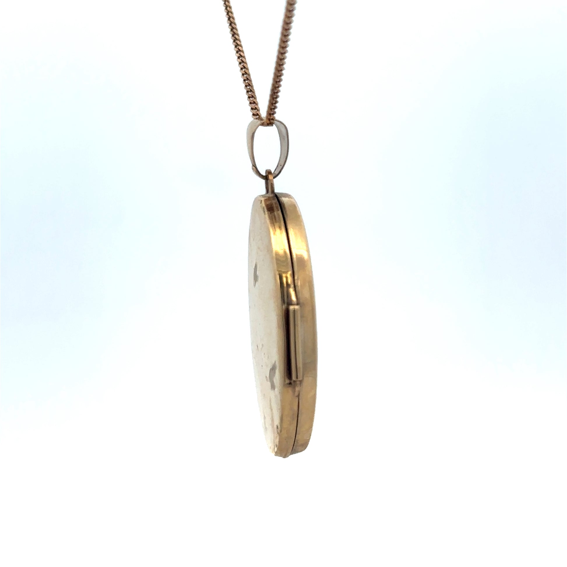 Reeves and Sons 9ct yellow gold locket pendant, 4.2g, featuring a classic oval design with intricate detailing.