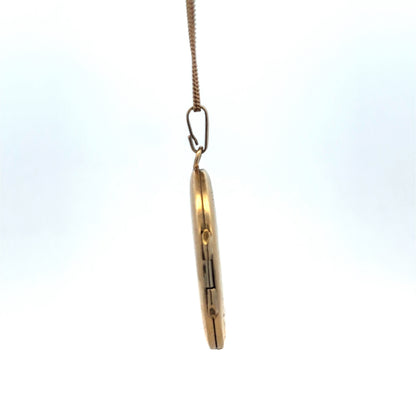 9ct yellow gold locket pendant with floral engraving, Reeves and Sons, weighing 5.4g, close-up view showing detailed craftsmanship.