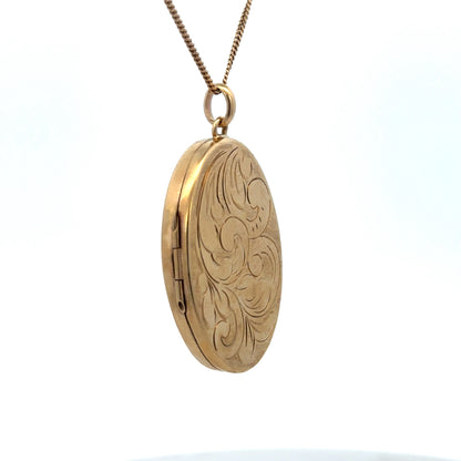 9ct yellow gold locket pendant with intricate design, weighing 9.3g, from Reeves and Sons, shown in close-up detail.