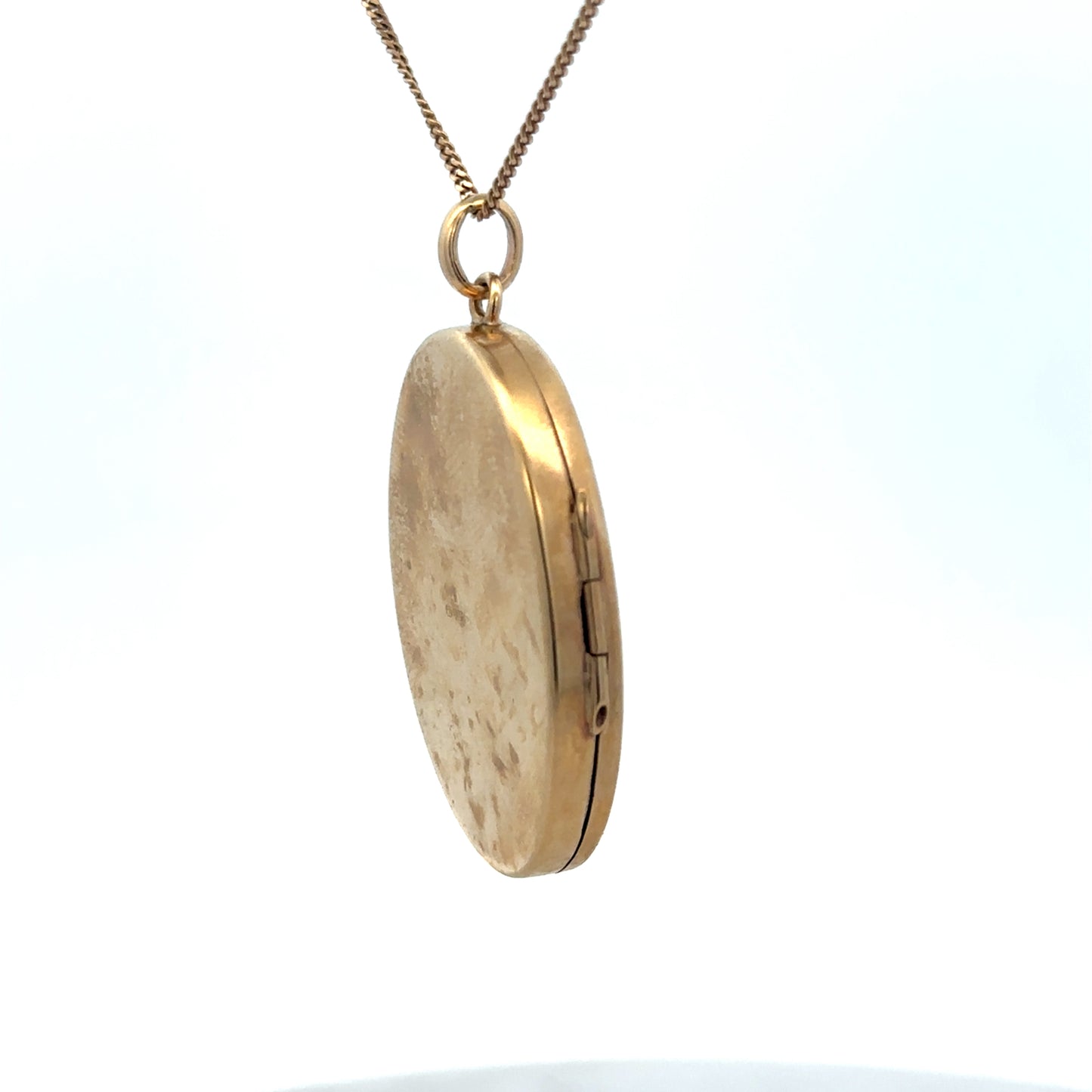 9ct yellow gold locket pendant with intricate design, weighing 9.3g, from Reeves and Sons, shown close-up.