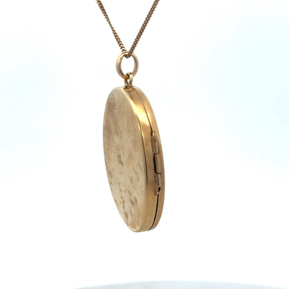 9ct yellow gold locket pendant with intricate design, weighing 9.3g, from Reeves and Sons, shown close-up.