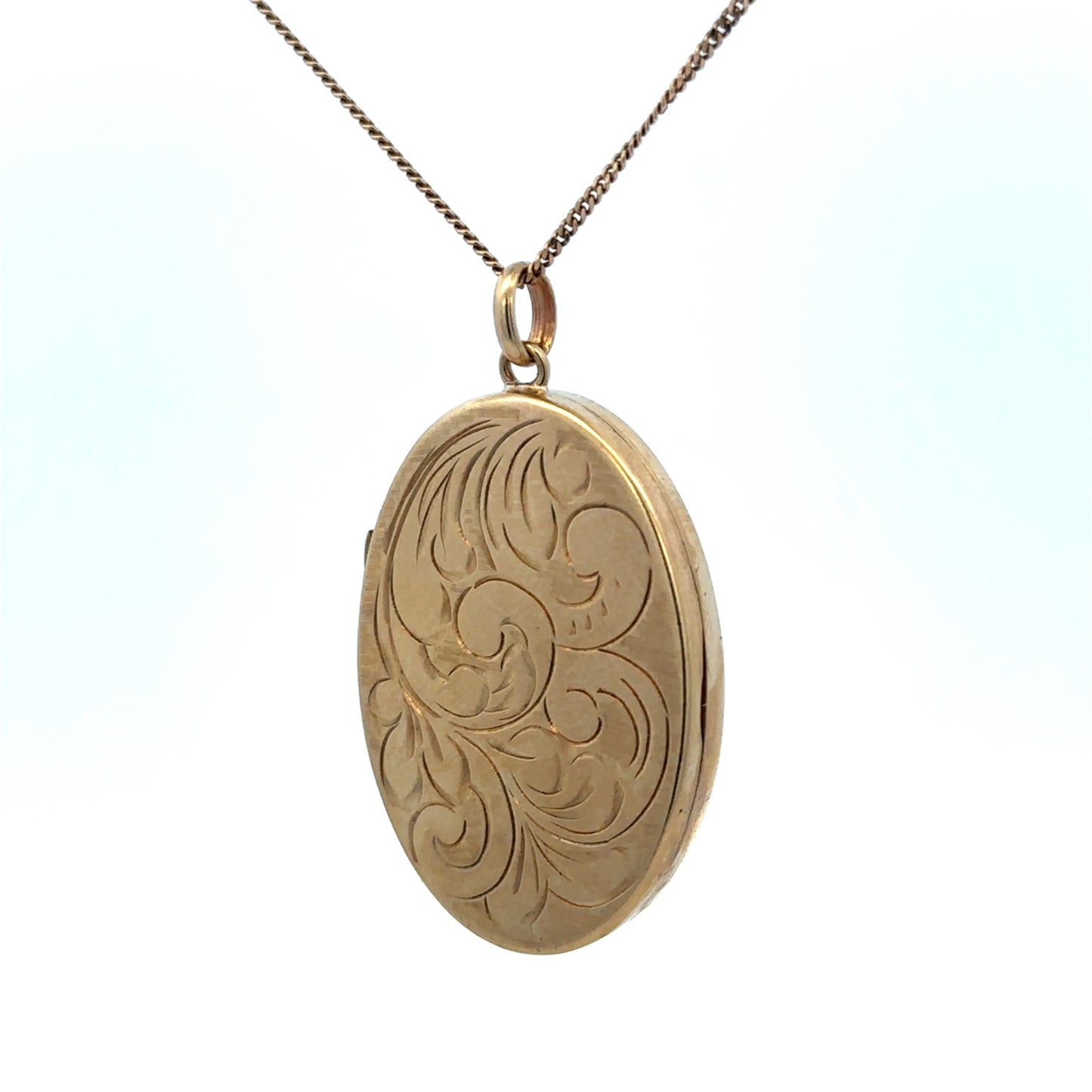 9ct yellow gold locket pendant with engraved design, weighing 9.3g, by Reeves and Sons, shown close-up with detailed craftsmanship.