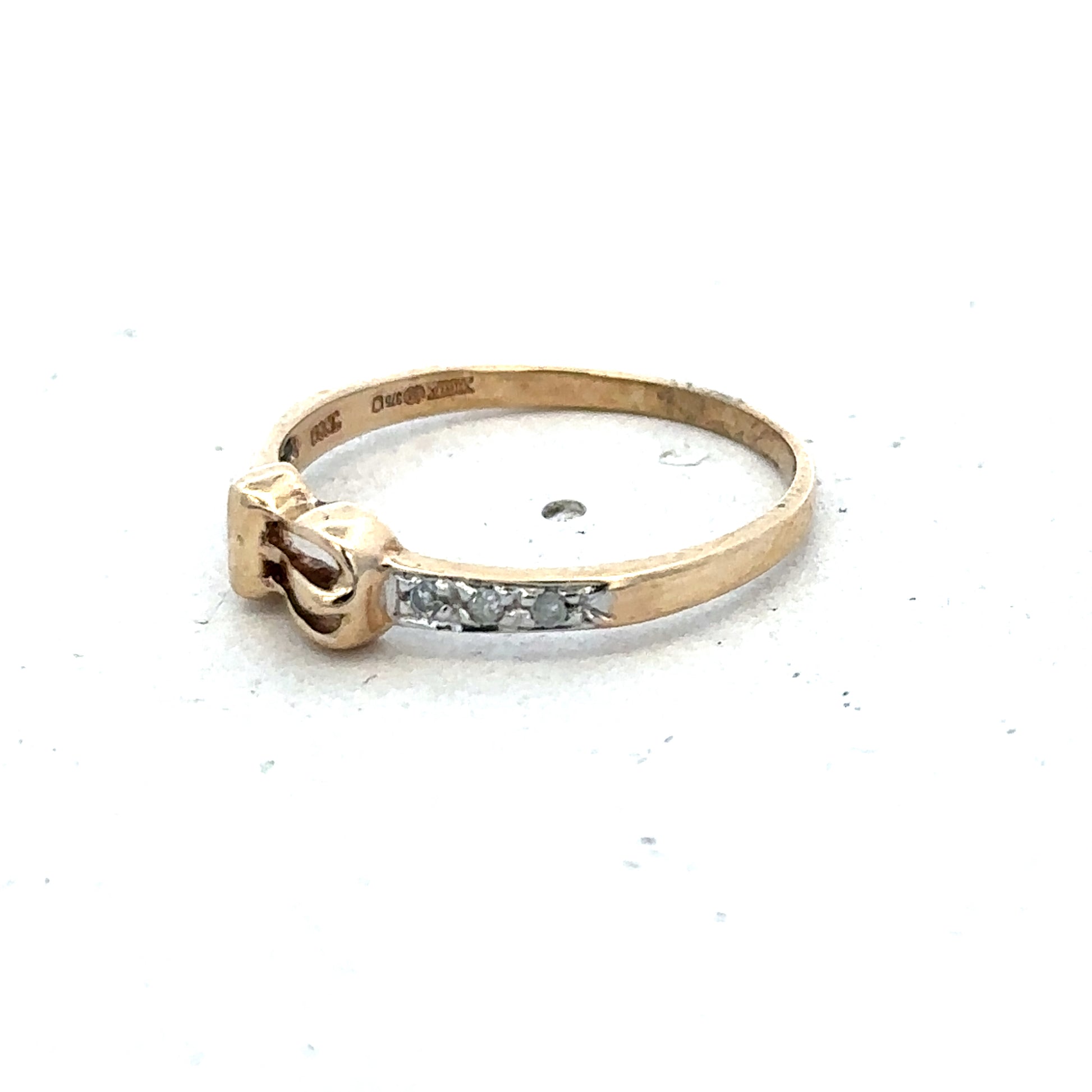 9ct yellow gold buckle ring in size M 1/2 with a polished finish, featuring a distinctive buckle design by Reeves and Sons.