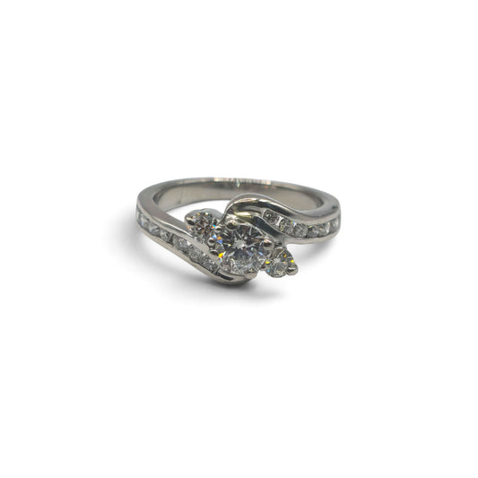 Platinum diamond twist ring by Reeves and Sons featuring a sleek design with sparkling diamonds and a twisted band.