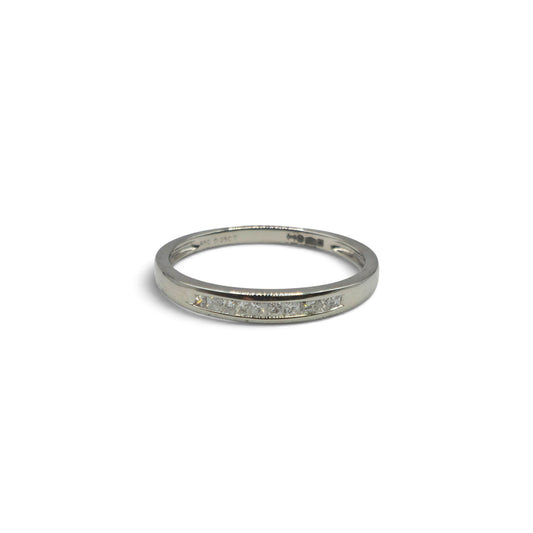 Platinum half eternity diamond ring by Reeves and Sons, featuring a band with sparkling diamonds on a sleek, elegant design.
