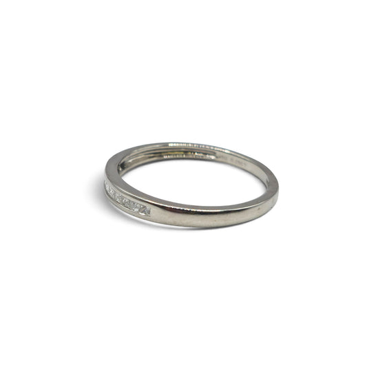 Platinum half eternity diamond ring by Reeves and Sons featuring alternating round cut diamonds on a sleek band.