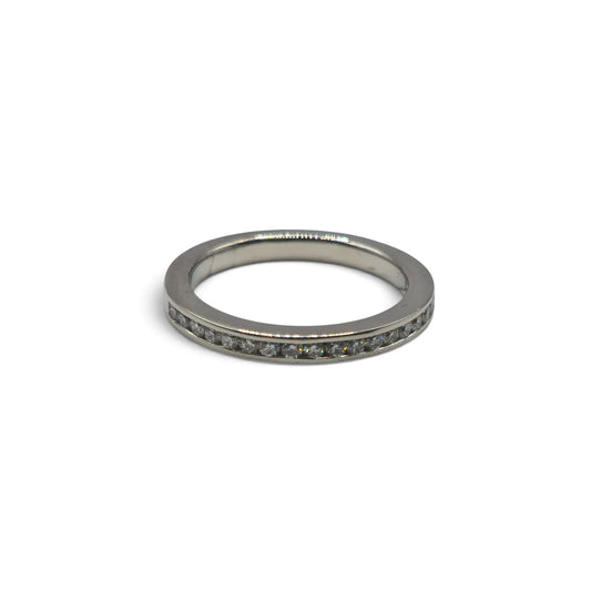 Platinum half eternity ring by Reeves and Sons featuring a continuous row of sparkling gemstones on a sleek band.