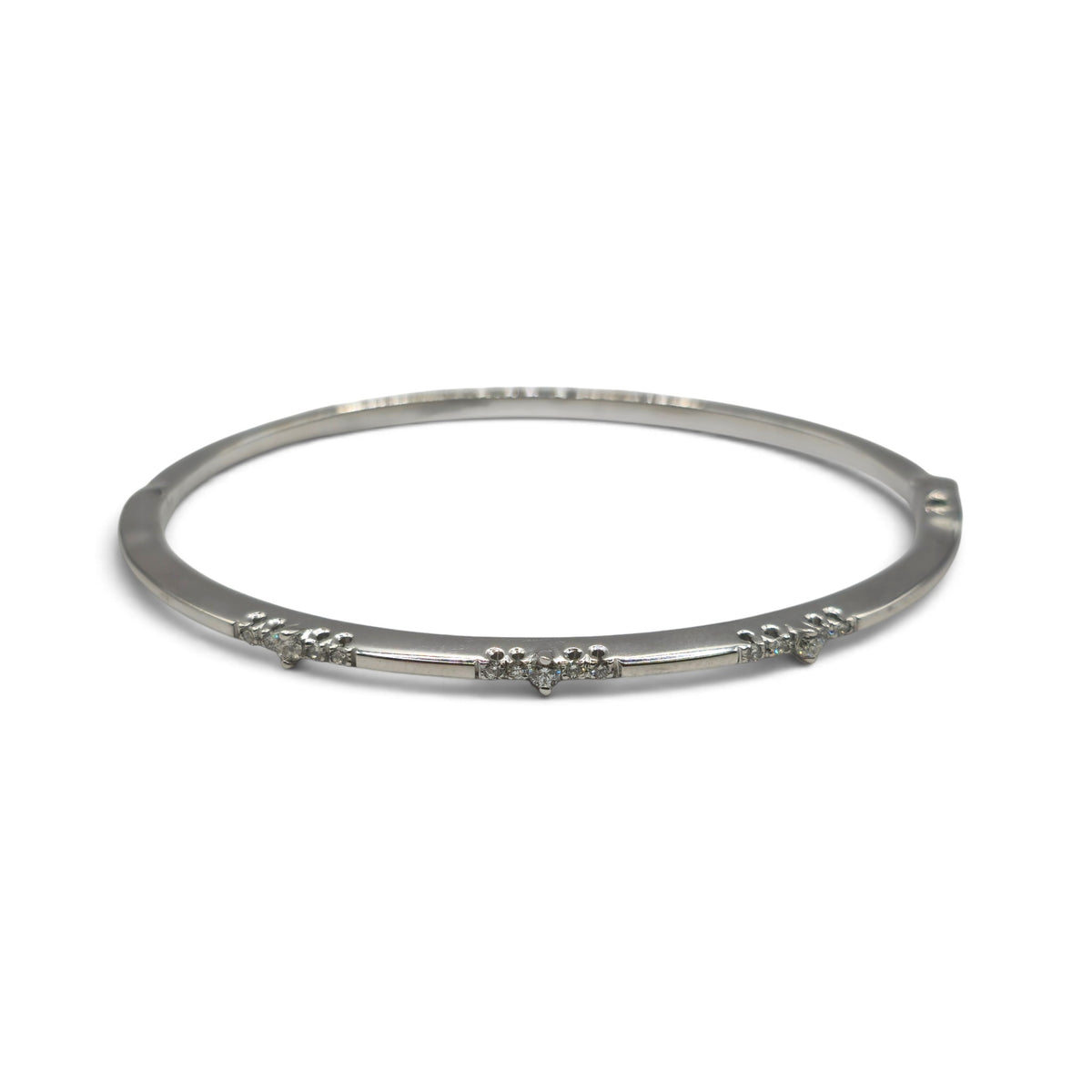 18ct white gold diamond bangle by Reeves and Sons, showcasing a sleek design with sparkling diamonds on a polished surface.