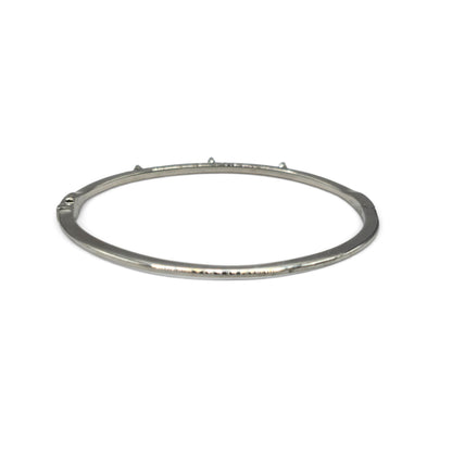 18ct white gold diamond bangle by Reeves and Sons with sparkling diamonds, showcasing a sleek and elegant jewelry design.