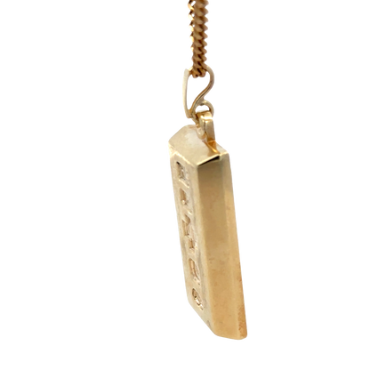 9ct yellow gold ingot pendant by Reeves and Sons, 34.2g, showcasing a polished gold bar with engraved details.