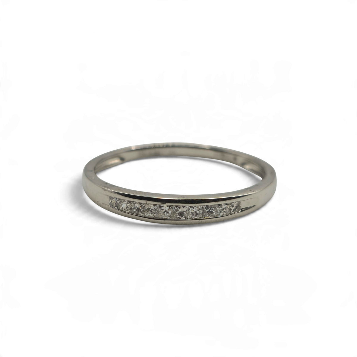 Platinum half eternity ring by Reeves and Sons, featuring a row of diamonds on the visible band