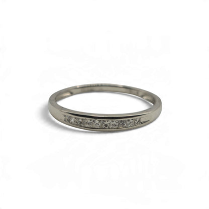 Platinum half eternity ring by Reeves and Sons, featuring a row of diamonds on the visible band