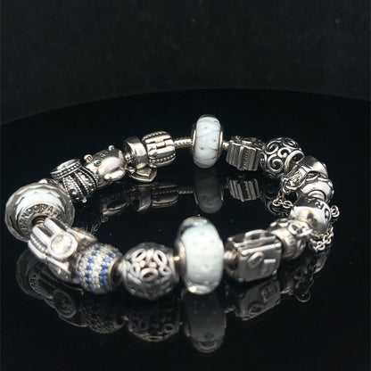 Silver Pandora charm bracelet by Reeves and Sons featuring intricate charms and a secure clasp, weighs 69.8g.