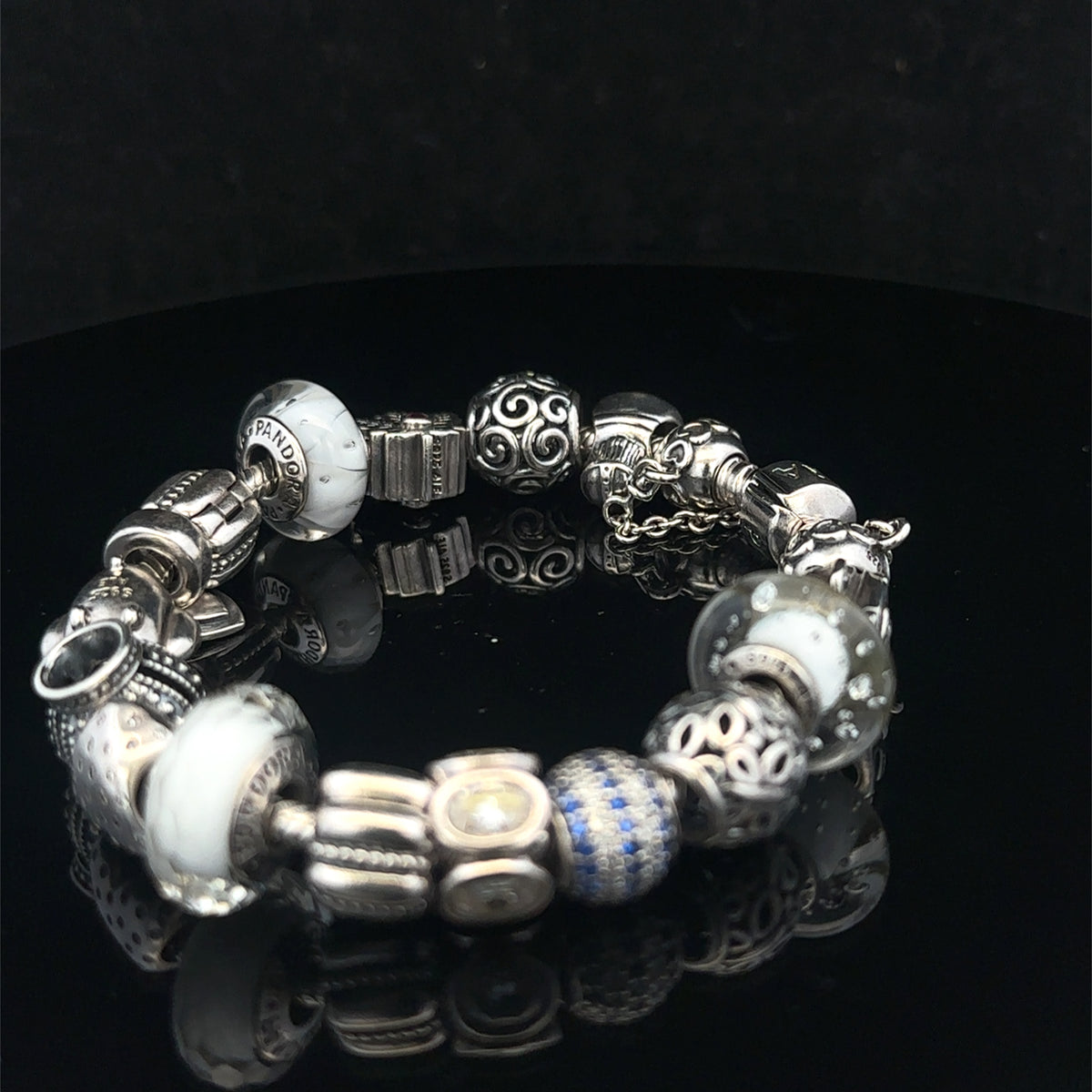 Silver Pandora charm bracelet by Reeves and Sons, 69.8g, featuring intricate charms and detailed craftsmanship.