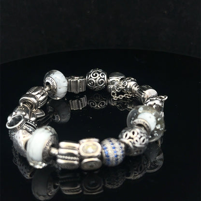 Silver Pandora charm bracelet by Reeves and Sons, 69.8g, featuring intricate charms and detailed craftsmanship.
