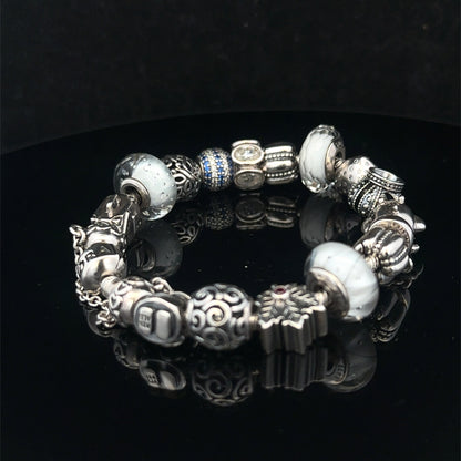 Silver Pandora charm bracelet by Reeves and Sons, weighing 69.8g, featuring detailed charms and a secure clasp.