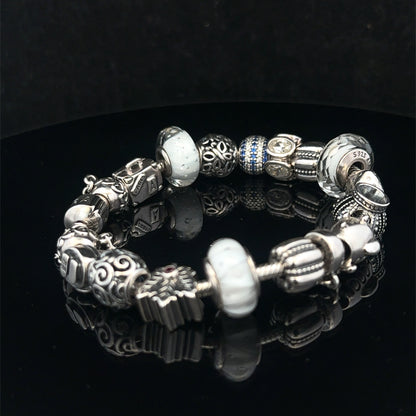 Silver Pandora charm bracelet by Reeves and Sons, weighing 69.8g, with intricate charms and a clasp detail.