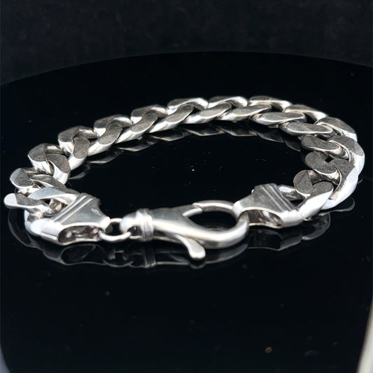 Silver curb bracelet by Reeves and Sons, 60.1g, featuring interlinked flat oval links, displayed on a neutral background.