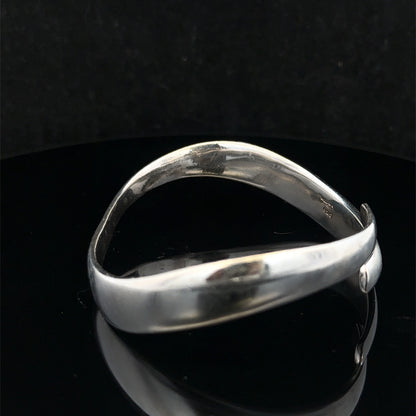 Silver bangle by Reeves and Sons weighing 45.1g, showcasing a smooth, polished design with intricate details.