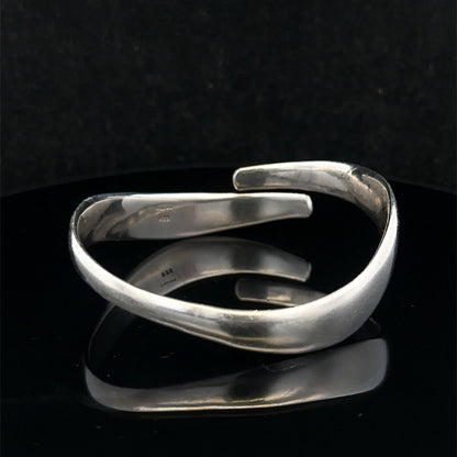 Silver bangle weighing 45.1g from Reeves and Sons, shiny jewelry piece with smooth, rounded design visible in the image.