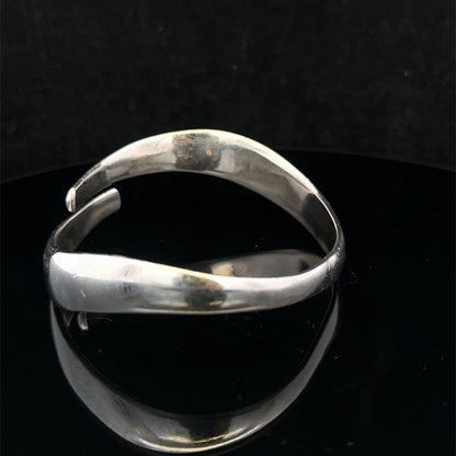 Silver bangle by Reeves and Sons weighing 45.1g, featuring a sleek, polished design with intricate detailing.
