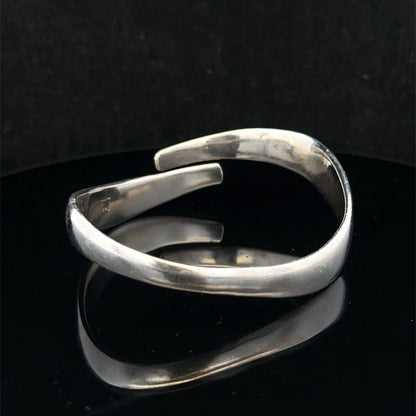 Silver bangle weighing 45.1g by Reeves and Sons, featuring a sleek, polished design with a smooth, rounded surface.