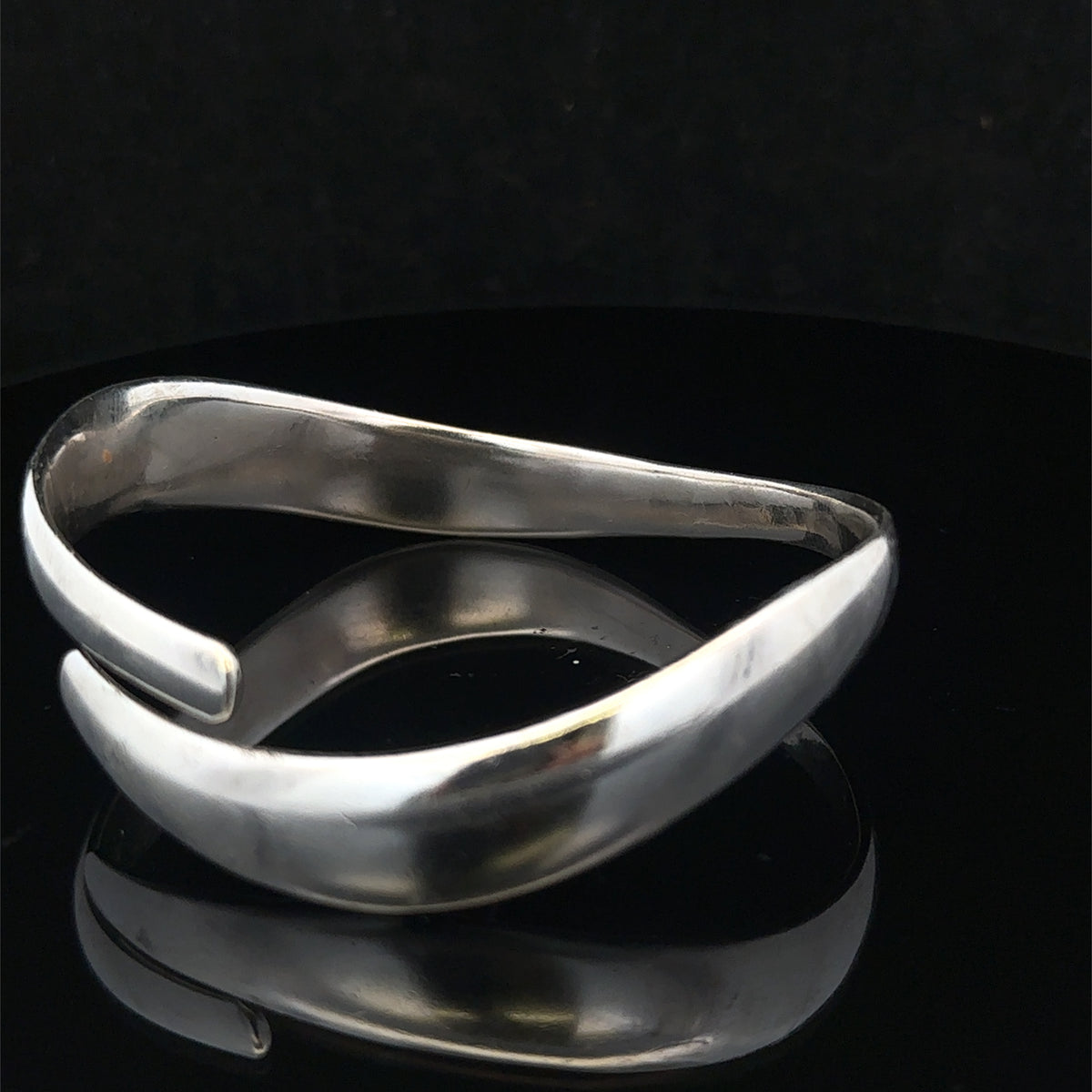 Silver bangle weighing 45.1g from Reeves and Sons, featuring a smooth, polished surface and classic round design.