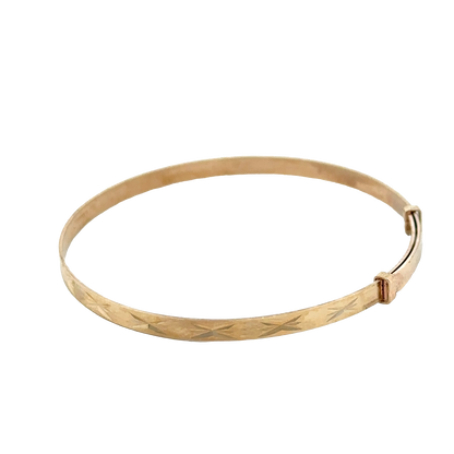 9ct yellow gold baby bangle with delicate design from Reeves and Sons, weighing 1.8g, shown in close-up image