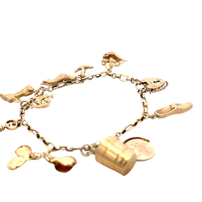 9ct yellow gold charm bracelet by Reeves and Sons, 16.3g, featuring multiple dangling charms