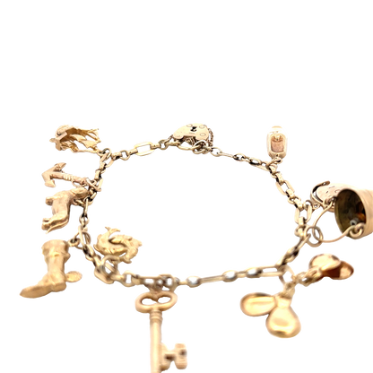 9ct yellow gold charm bracelet by Reeves and Sons, 16.3g, featuring multiple hanging charms